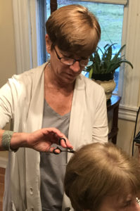 Chris cutting a customer's hair at her hair salon in Purcellville Va